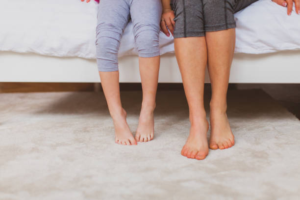 istock Low Section Of Couple Standing On Bed 1310089670