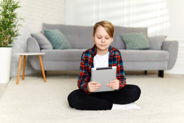 istock child boy in checkered shirt using digital tablet 1310089673