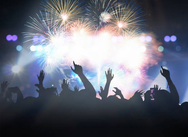 istock Rear View Of People Enjoying Firework Display At Night 1310089736