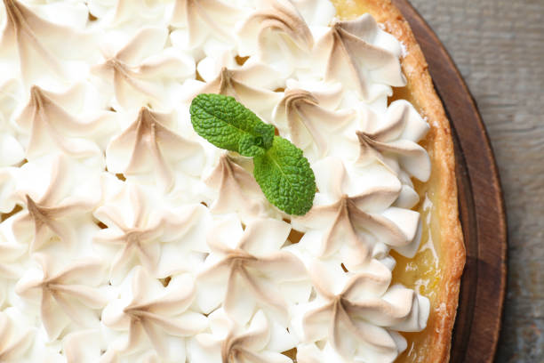 istock Delicious lemon meringue pie decorated with mint on wooden table, top view 1310090147