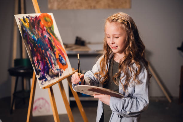 istock Young girl creative artist at work in a workshop. With passion draws a picture immersed in work 1310091027