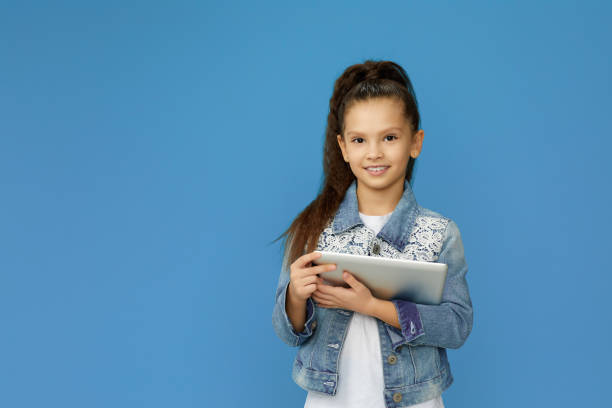 istock little child girl in denim using digital tablet 1310091133