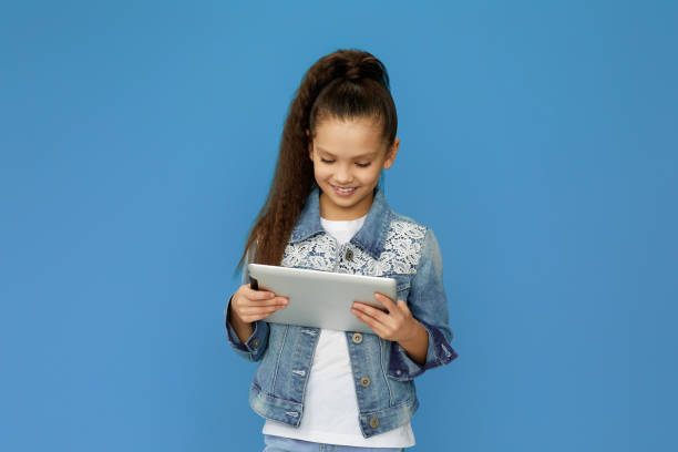 istock little child girl in denim using digital tablet 1310091146