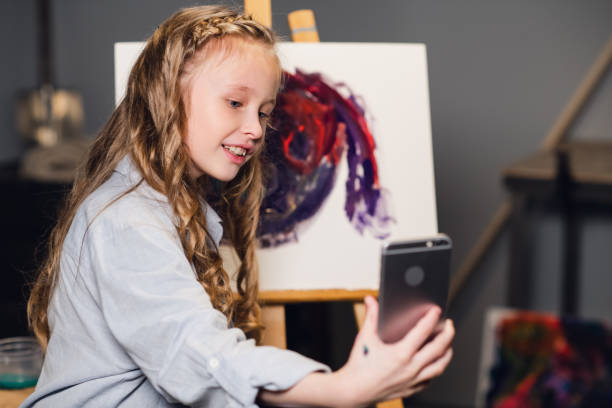 a young charming artist leads an online masterclass in drawing pictures in her workshop