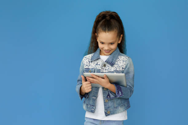 istock little child girl in denim using digital tablet 1310091155