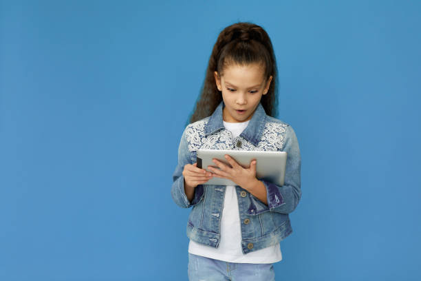 istock little child girl in denim using digital tablet 1310091160