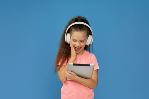 istock little child girl in headphones using digital tablet 1310092132