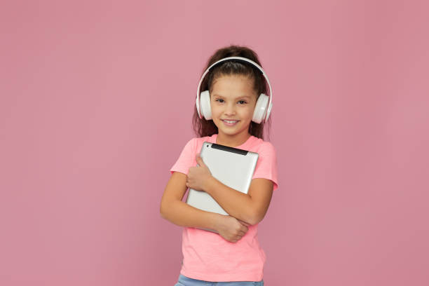 istock little child girl in headphones using digital tablet 1310092217
