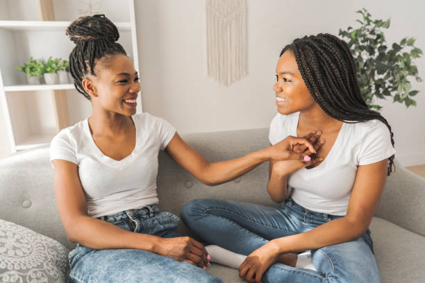 istock Mother and daughter sitting on sofa at home talking 1310093857
