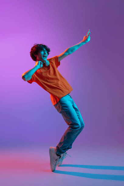 Happy man in casual clothes isolated over gradient background in neon light