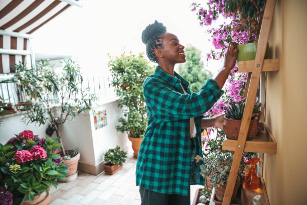 Beautiful woman taking care of her terrace garden at home