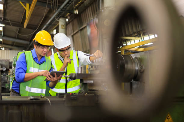 istock Asian engineering manager and mechanic worker in safety hard hat and reflective cloth using lathe machine in the factory 1310096080