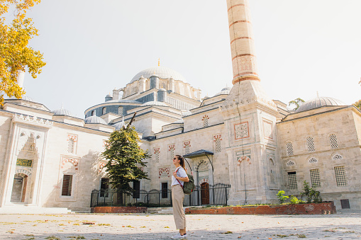 Woman with long hair and backpack traveling in Turkey exploring the beautiful old district of Istanbul during sunny warm day