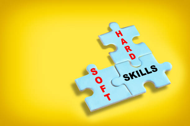 Soft skills and hard and skills written on blue puzzle jigsaw with shadow on yellow background stock photo