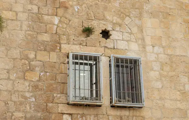 Windows with metal bars on the facade of an old building in the old city of Jerusalem, Israel
