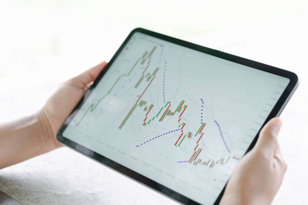 istock Business woman hand holding digital tablet computer with graph of Binary option for trading platform, setective focus 1310097400
