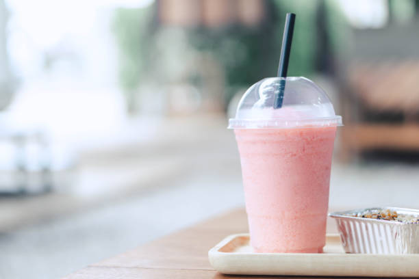 istock Closeup  strawberry smoothie and cake with green nature background, selective focus 1310097413