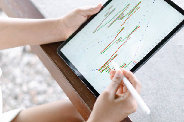 istock Business woman hand holding digital tablet computer with graph of Binary option for trading platform, setective focus 1310097447