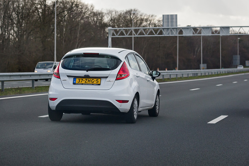 Holten, Overijssel, Netherlands, march 27th 2021, rear view of a Dutch white 6th generation 2012 Ford Fiesta supermini on the dutch highway A1 near Holten - the motorway crosses 4 provinces: North Holland, Utrecht, Gelderland and Overijssel from Amsterdam to the German border, 157 kilometers in total