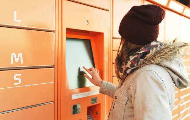 istock Woman picks up mail from automated self-service post terminal machine. 1310103410