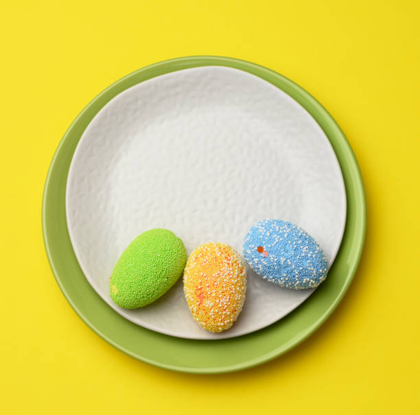 istock decorative easter eggs in a round white ceramic plate on a yellow background 1310104503