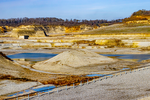 Excavation site, mounds, a pond with blue water in the old marl quarry mine in Sint-Pietersberg or Mount St. Peter, part of the Caestert plateau in South Limburg, the Netherlands