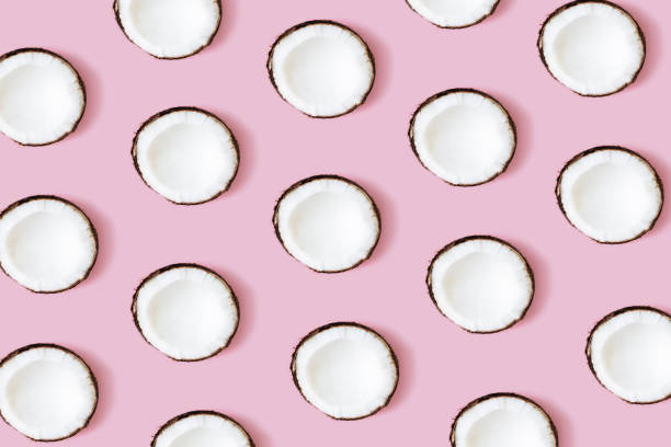 istock Coconut pattern on the pink background. Set of coconut halves 1310105079