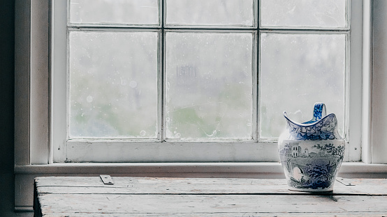 sitting at home the word in English written by hand hanging on a window of a house