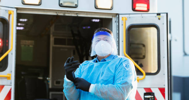 istock Paramedic putting on PPE during COVID-19 1310106214