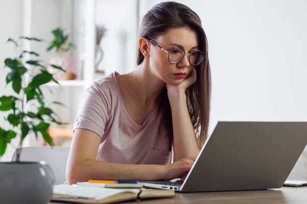 istock Young woman using laptop to work at home 1310106281