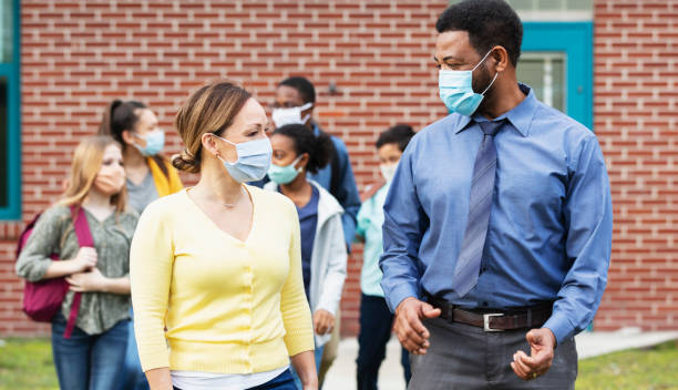 istock Teachers, middle school students walking outside building 1310106428