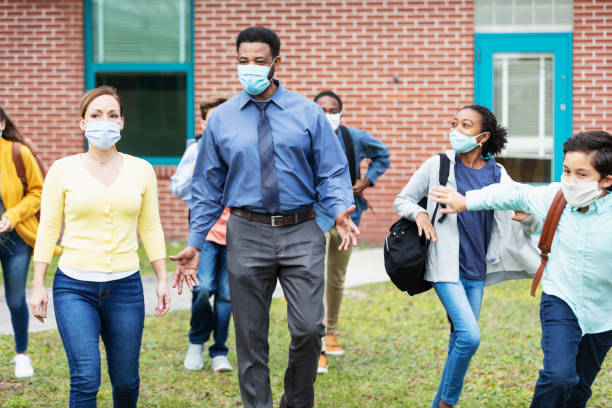 istock Teachers, middle school students walking outside building 1310106477