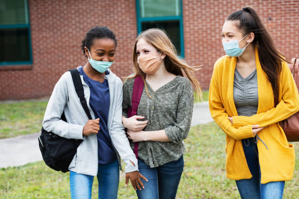 istock Three middle school girls walking, talking outdoors 1310106508