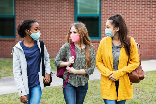 istock Three middle school girls walking, talking outdoors 1310106531