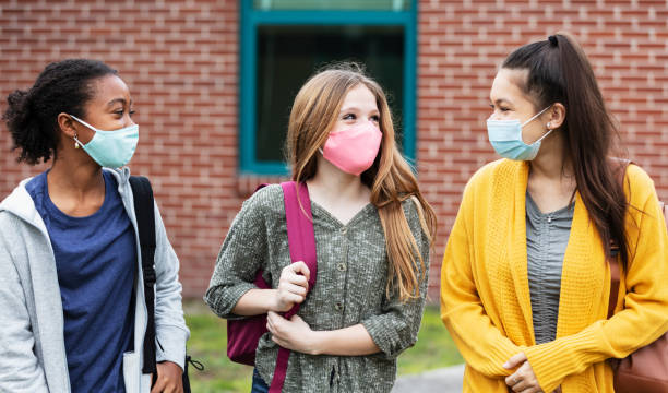 Three middle school girls walking, talking outdoors