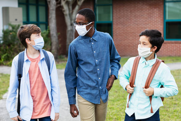 istock Three middle school boys walking, talking outdoors 1310107084