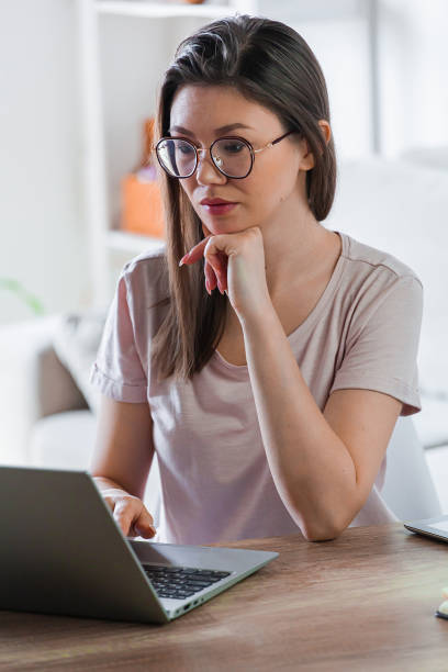 istock Young woman using laptop to work at home 1310107233