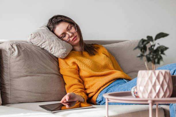 istock Young woman sleep on sofa using digital tablet 1310107354