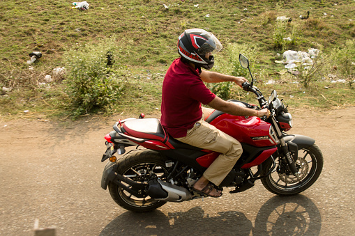 16 March, 2019, Kolkata: A biker riding bike on rural road in West Bengal India.