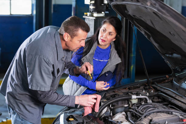 istock Auto mechanic checking oil while customer watches 1310107783