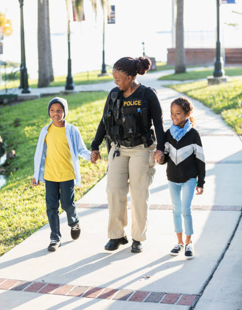 istock Policewoman in the community, walking with two children 1310108702