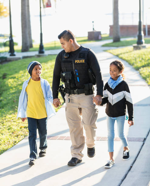 istock Police officer in community, walking with two children 1310108715