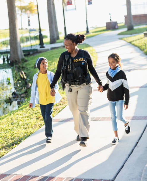 istock Policewoman in the community, walking with two children 1310108717