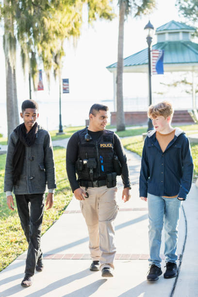 istock Police officer in community, walking with two youths 1310108728