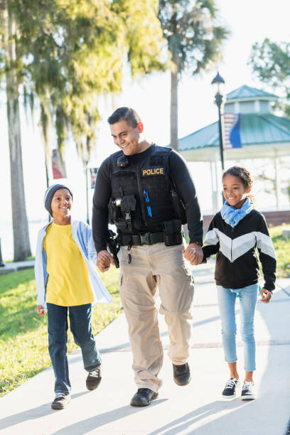 istock Police officer in community, walking with two children 1310108730
