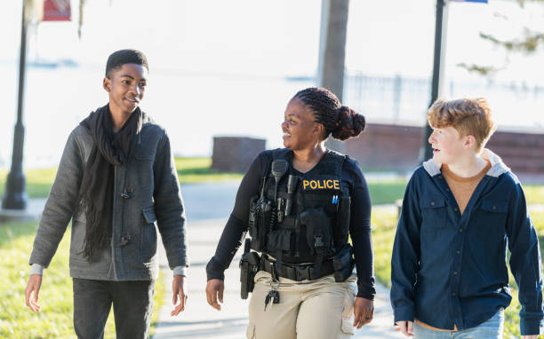 istock Policewoman in community, walking with two youths 1310108737