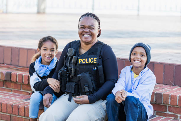 istock Policewoman in the community, sitting with two children 1310108791