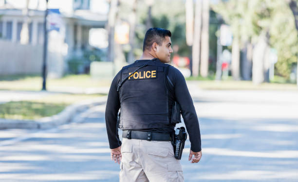istock Hispanic police officer walking in community 1310108962