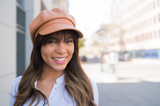 Close-up of young woman smiling while standing outdoors on the street. Urban concept.