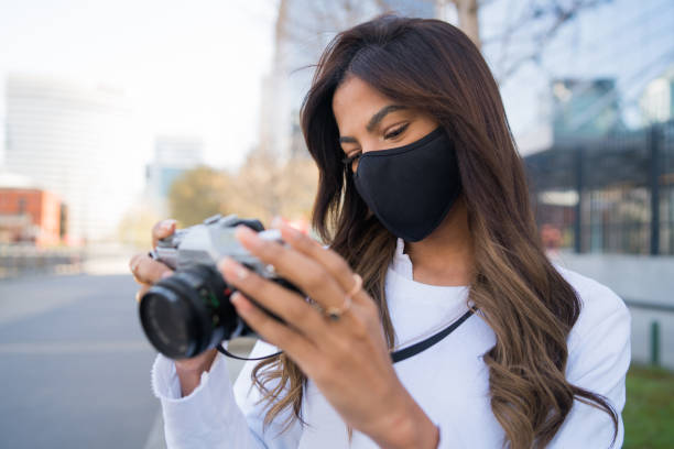 istock Young woman using camera outdoors. 1310109064